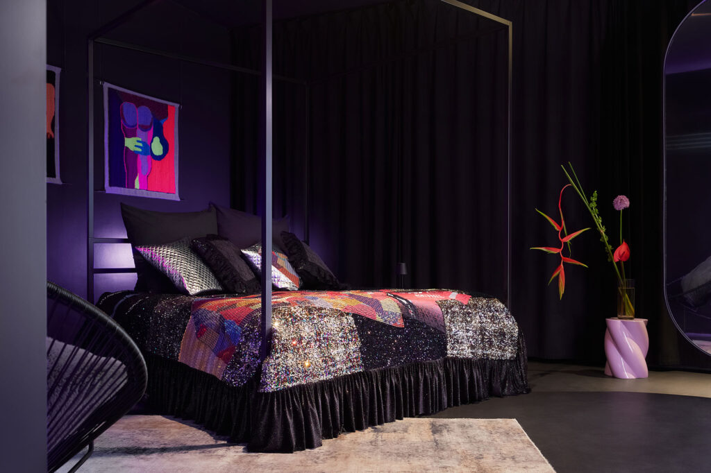 A custom-made kingsize 4-poster bed with a luxurious sequined bedspread by Tata Christiane, accented by giant designer flowers and premium artwork by Florencia Martina inside The Circle Berlin private spa suite.