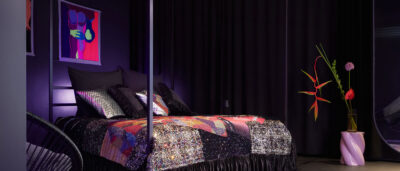 A custom-made kingsize 4-poster bed with a luxurious sequined bedspread by Tata Christiane, accented by giant designer flowers and premium artwork by Florencia Martina inside The Circle Berlin private spa suite.