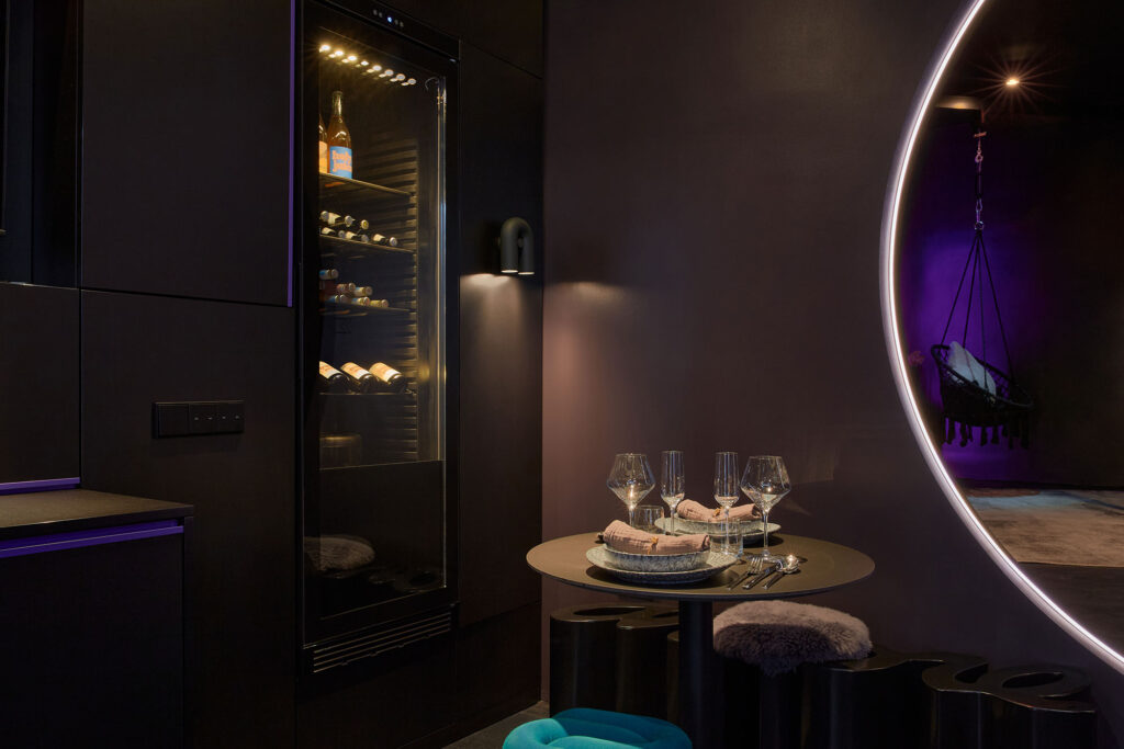 A close-up view of a luxury table set up for a romantic dinner for two under cozy, intimate low lighting inside The Circle Berlin private spa suite.