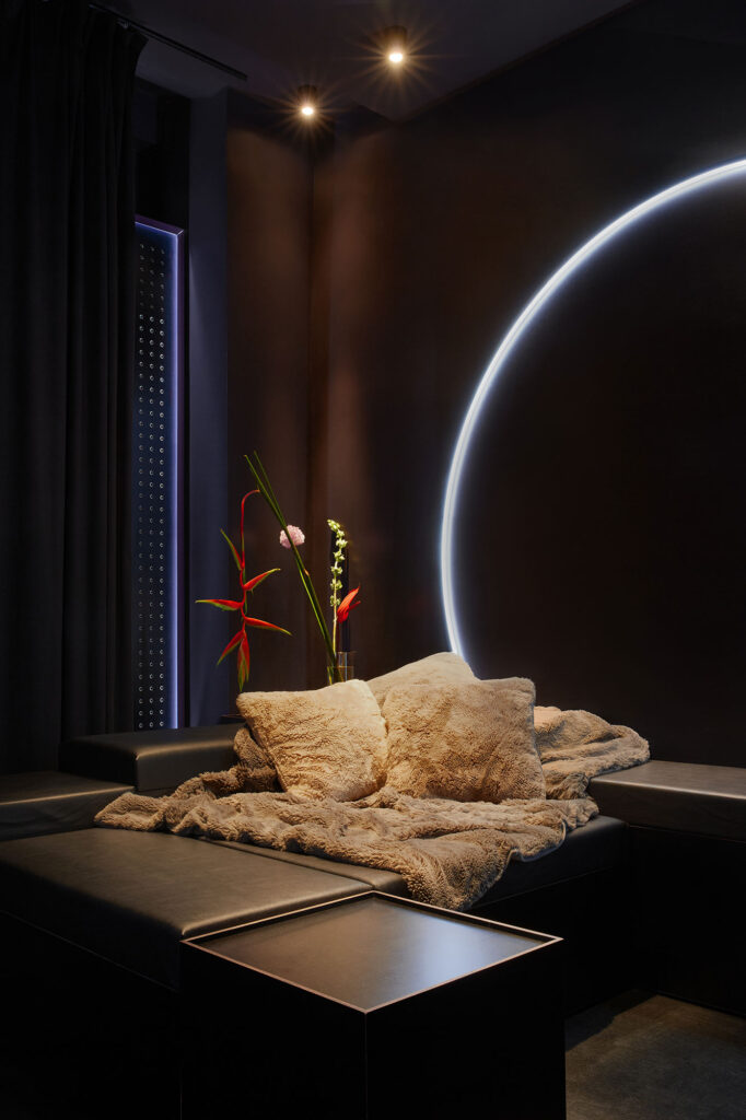 A detailed view of the modular sofa styled with plush luxury rugs and beautiful fresh flowers inside The Circle Berlin private spa retreat.